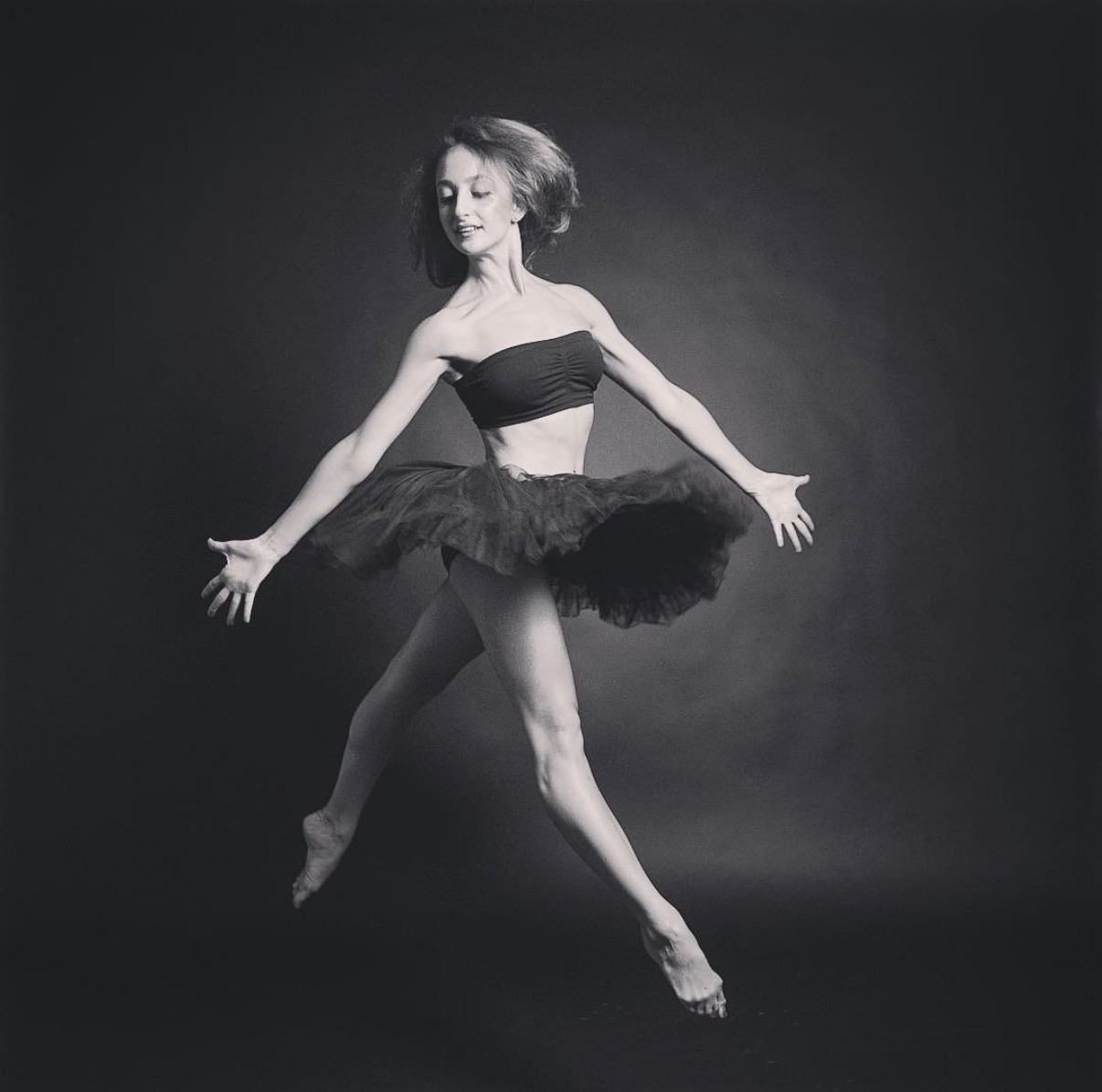 Buse Babadag in black tutu, leaping — black and white studio portrait