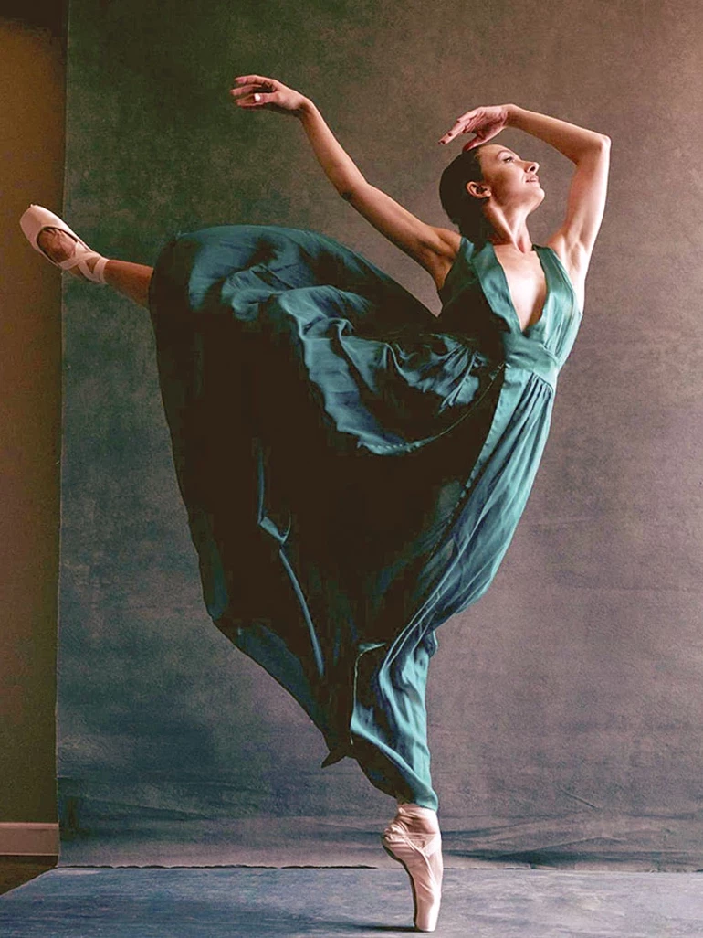 Buse Babadag in teal dress performing arabesque en pointe — studio portrait
